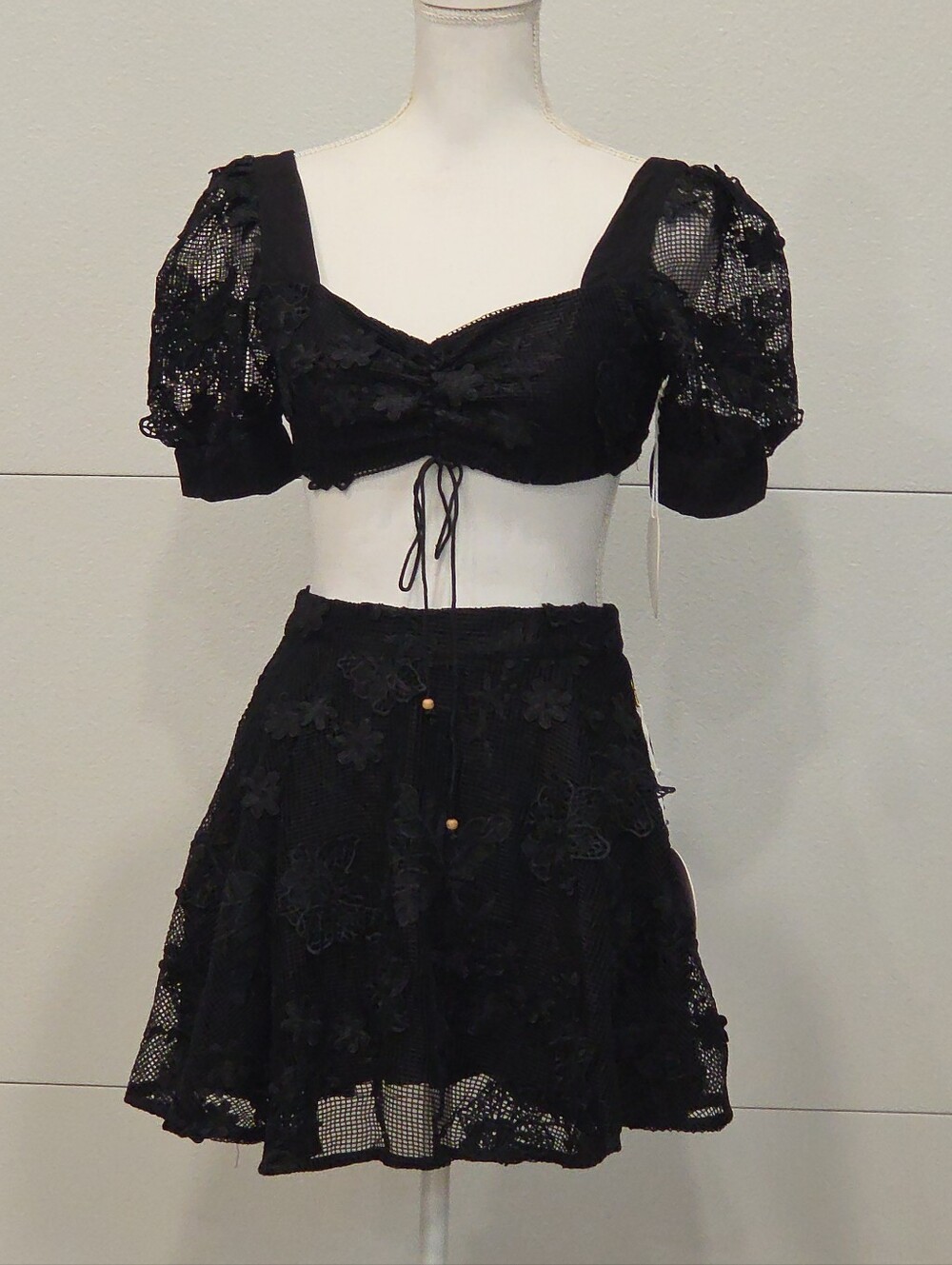 Black crochet puff sleeve crop and skirt featuring intricate floral detailing